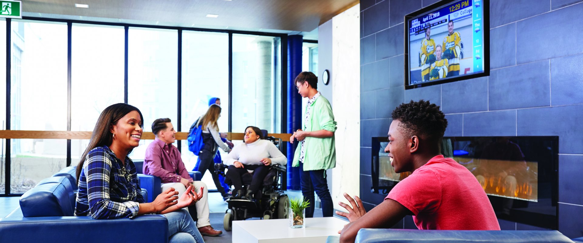 Students gather in a lounge area; one student is in a wheelchair