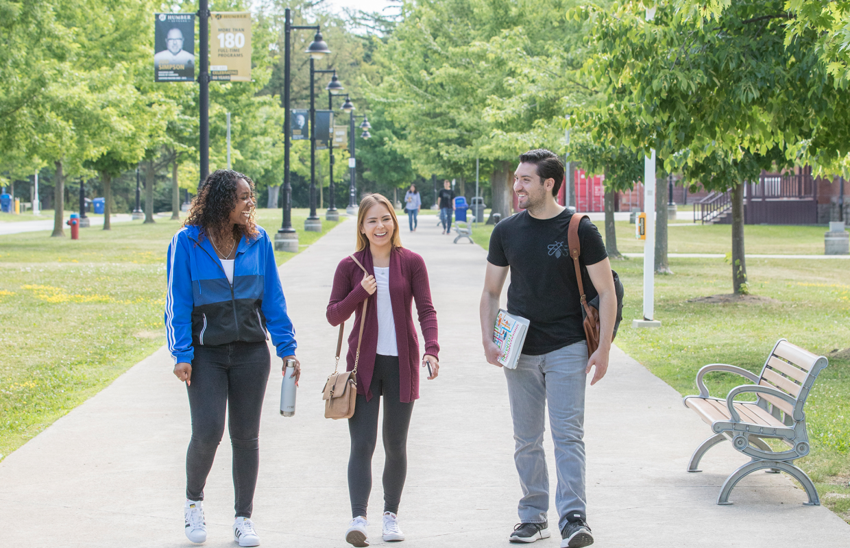 three students walking along an outdoor pathway