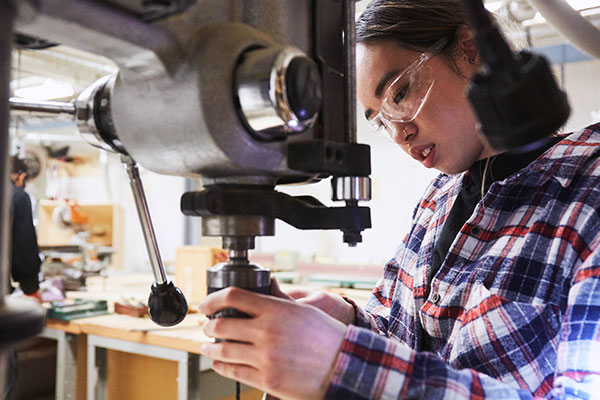 female working with a drill press