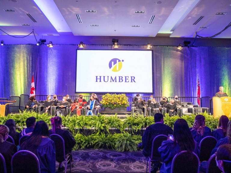 The ceremony stage with seated faculty and a large display of the Humber logo