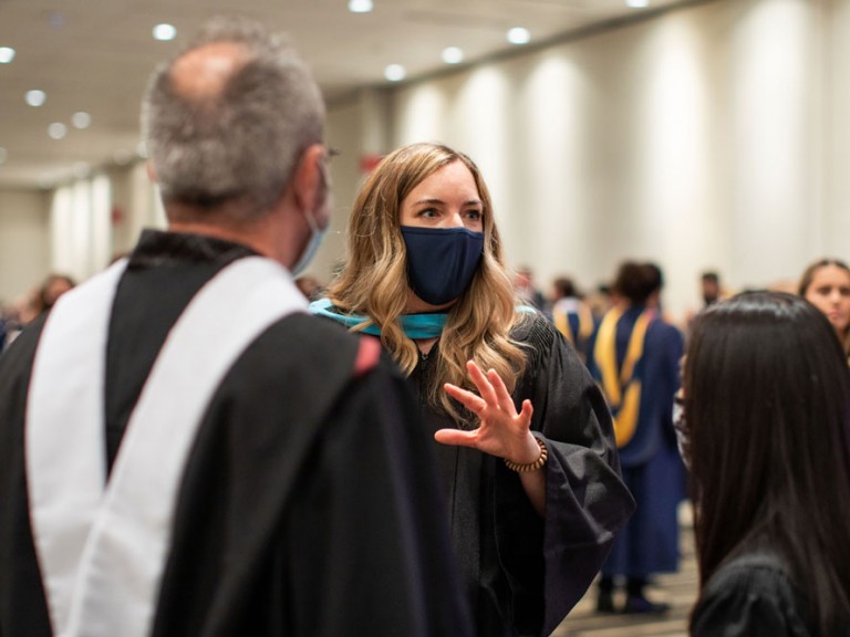 Person wearing a face mask talking to two other people