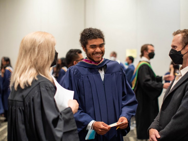 Humber graduate smiling with two other people wearing face masks