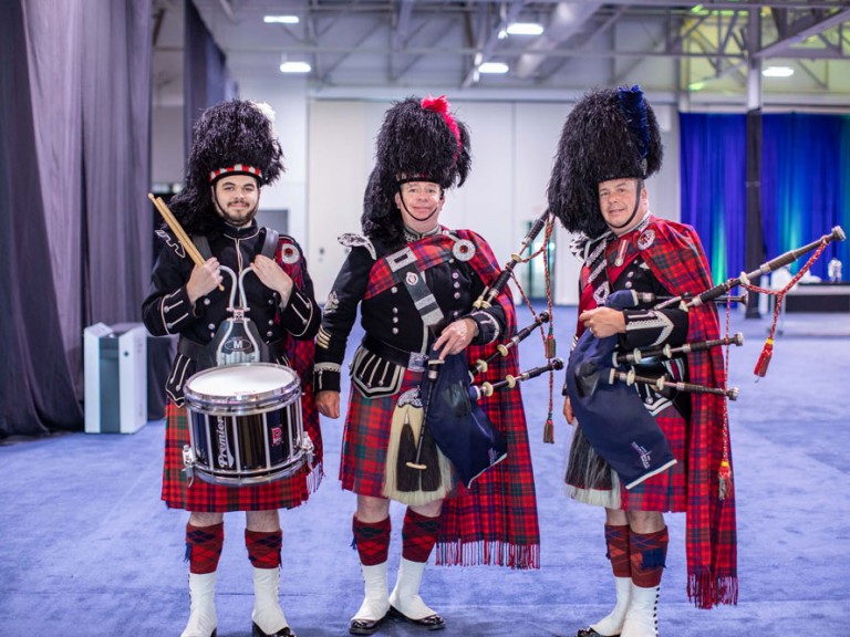 Three people in Scottish formalwear with bagpipes and drums