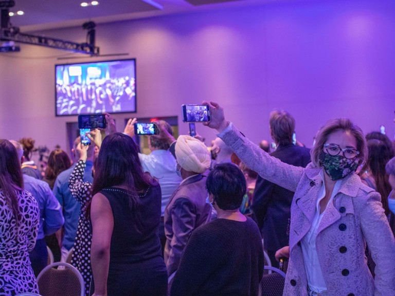 Group of attendees taking cell phone photos