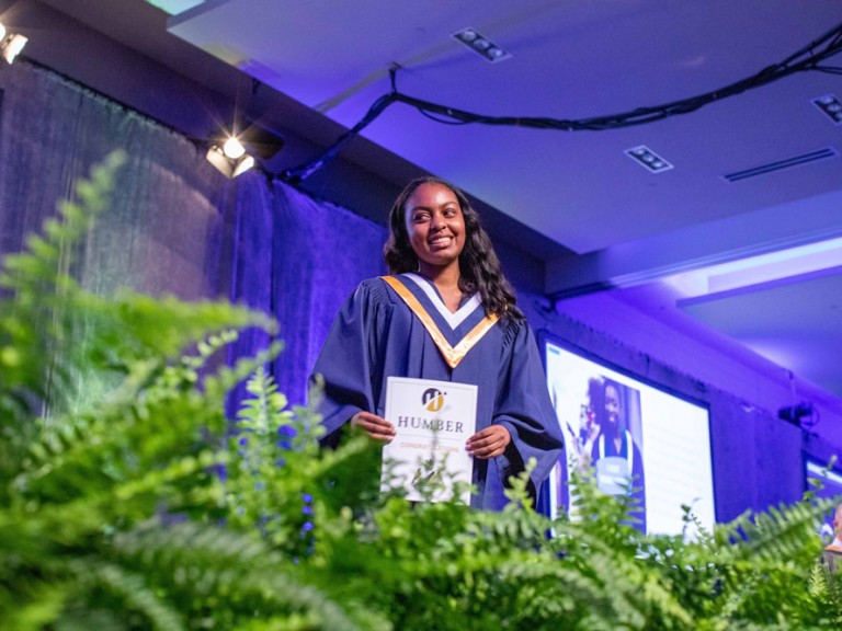 Graduate holding their diploma