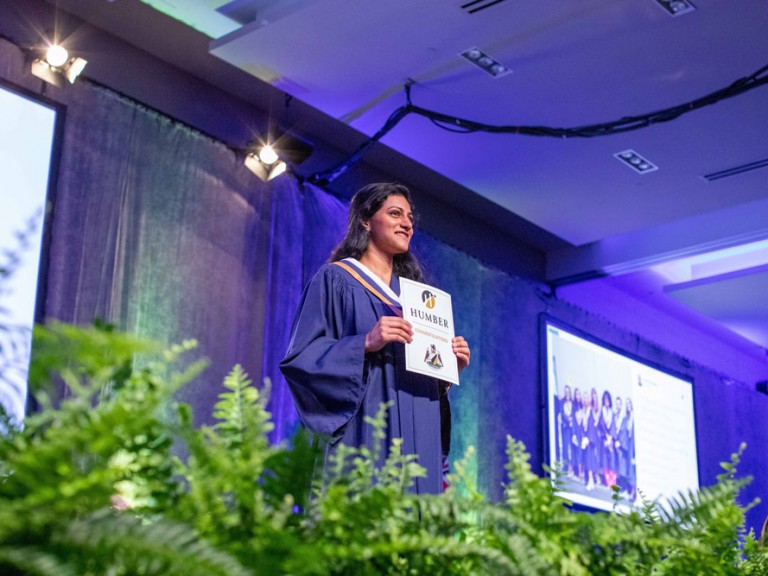 Graduate smiling facing the audience