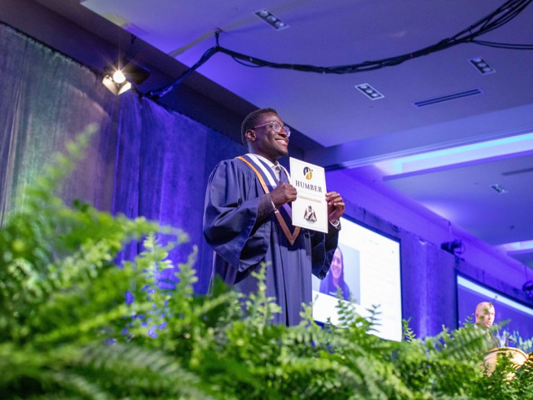 Graduate holding their diploma