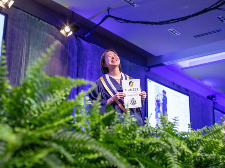 Graduate laughing on stage