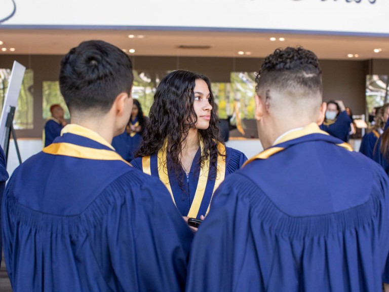 Humber graduate looking to the side in front of two other graduates