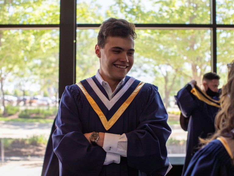 Humber graduate crossing their arms and smiling