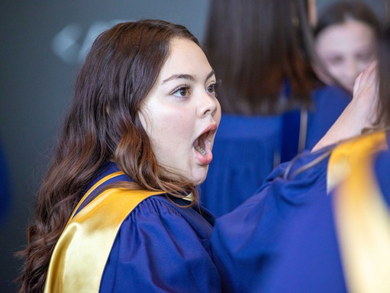 Graduate looking at someone with a shocked face
