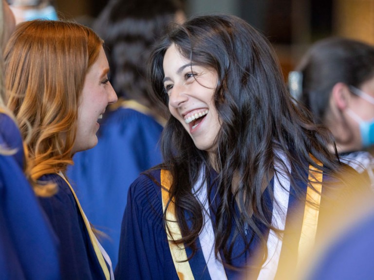 Two graduates laughing together