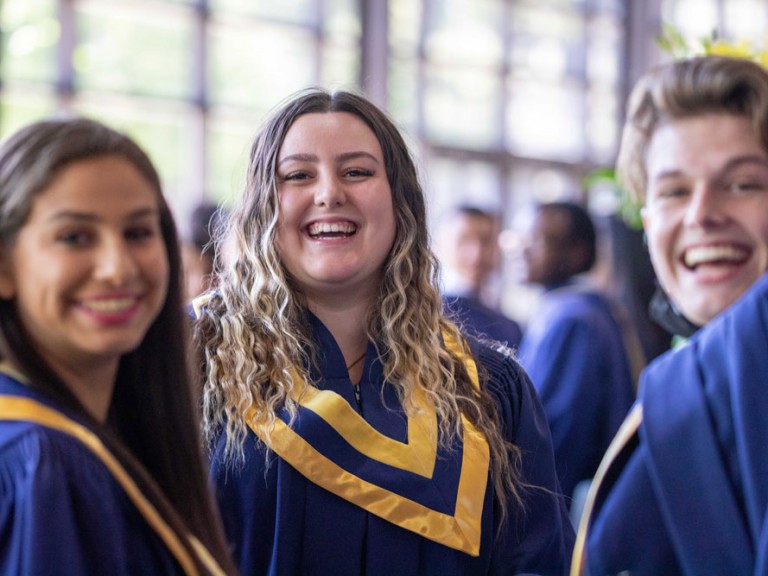 Three graduates smiling