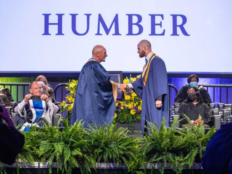 Two people on stage shaking hands