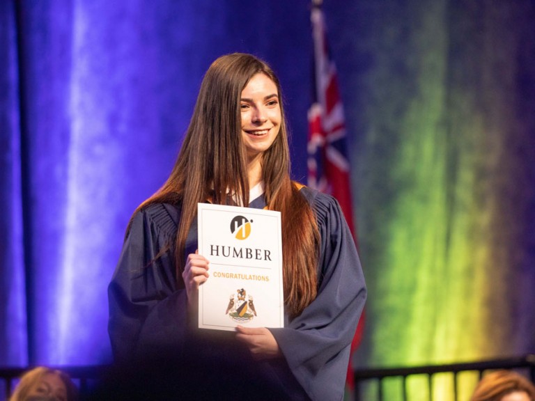 Humber graduate smiling on stage