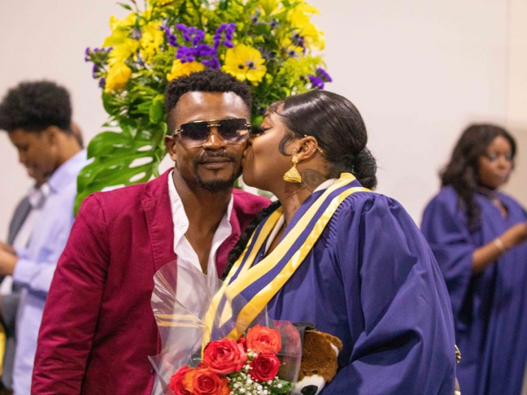 Graduate kissing someone on the cheek