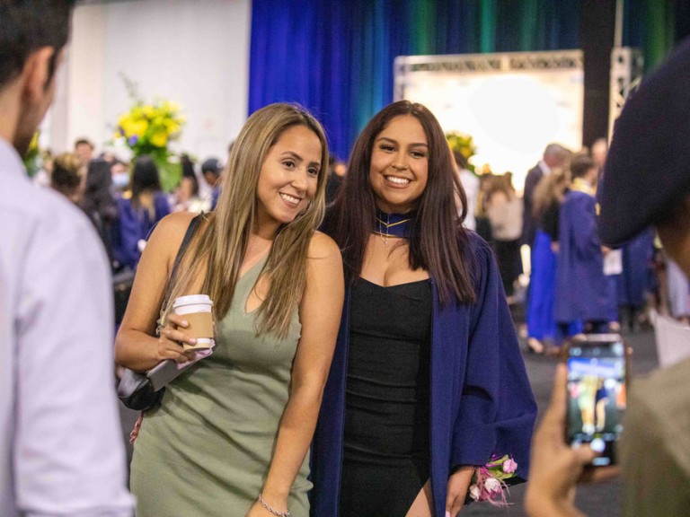 Graduate posing for a photo with someone