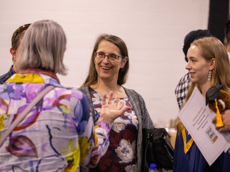 Graduate talking with ceremony guests