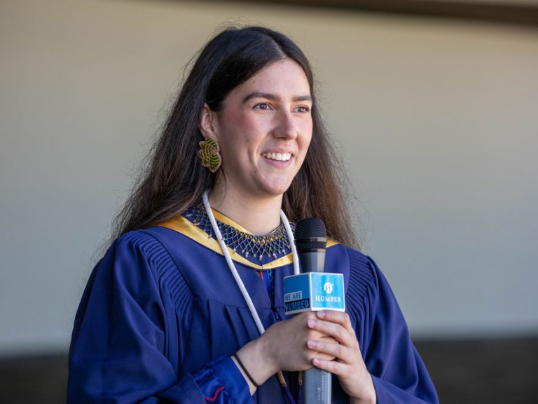Humber Indigenous graduate with a microphone