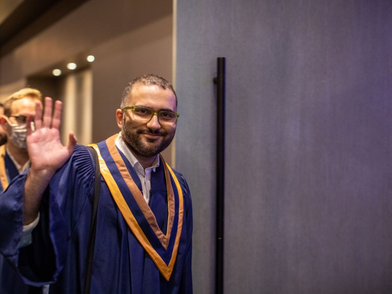 New Graduate waving to camera
