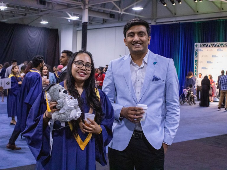 Humber graduate smiling at camera with friend