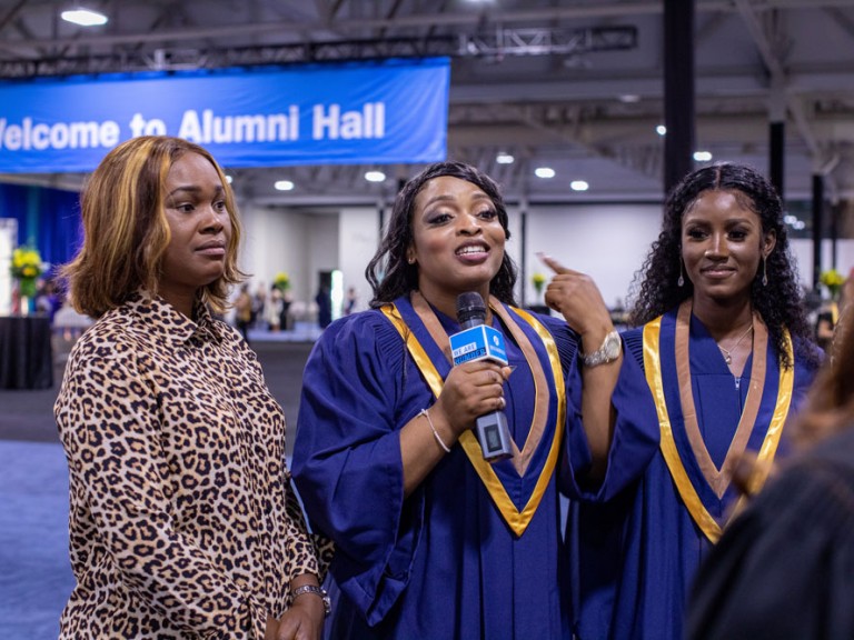 Graduate holding a microphone