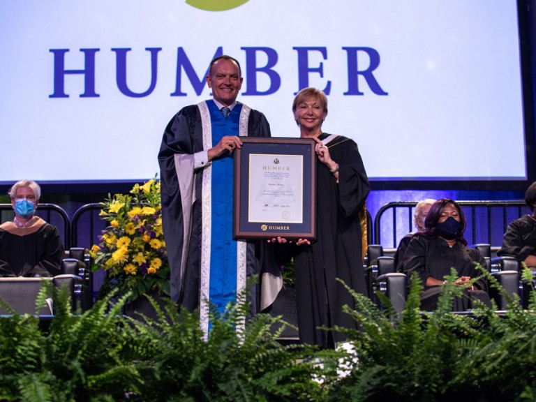 Chris Whitaker holding framed document with someone