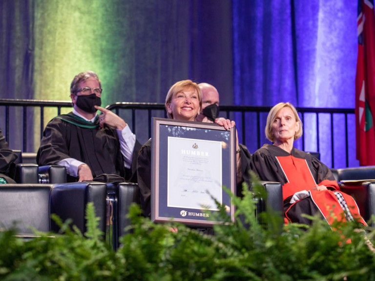 Person smiling with framed document