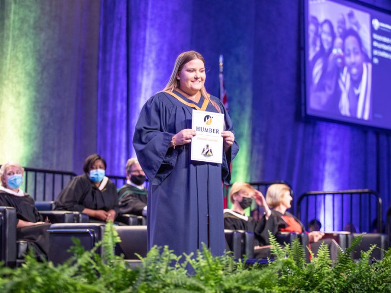 graduate on stage smiling