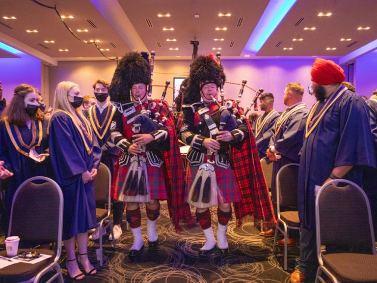 bagpipe players in Scottish formalwear proceed down aisle