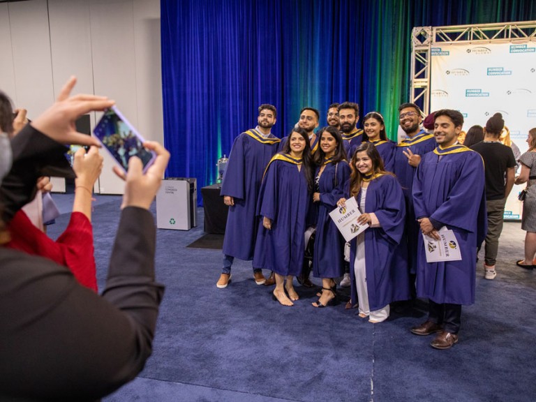 person takes photo of graduates
