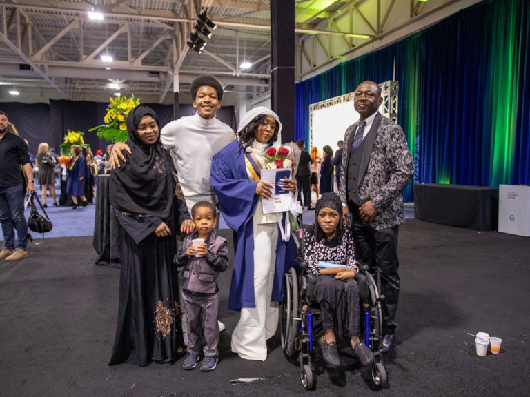 graduate poses with their family