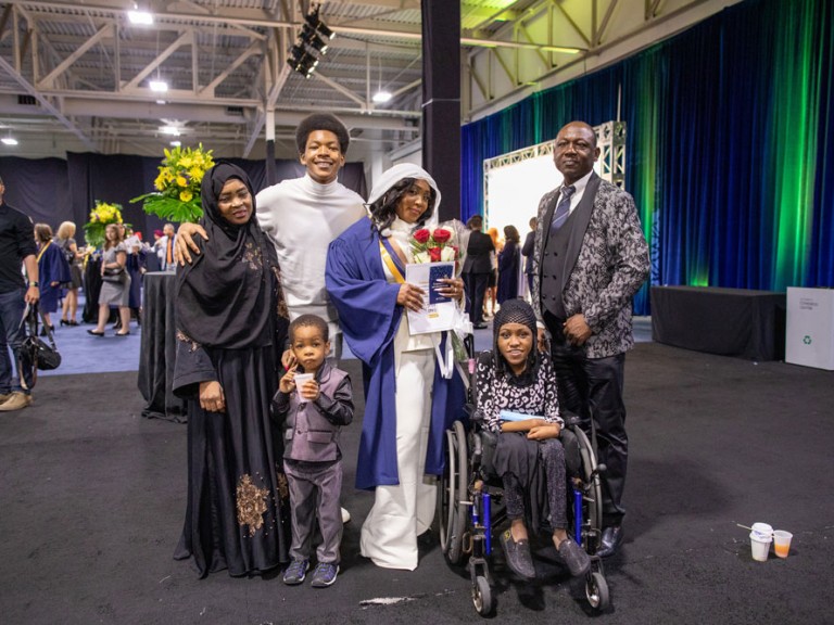 graduate poses with family members