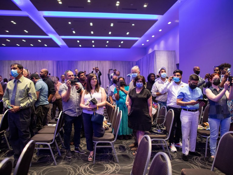 ceremony attendees standing in front of their seats