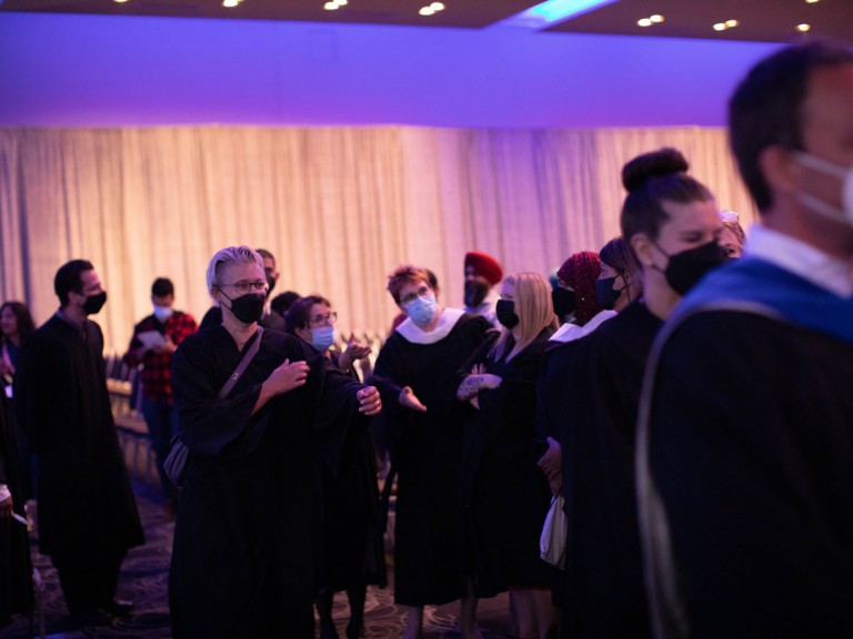 Graduates standing and talking to each other