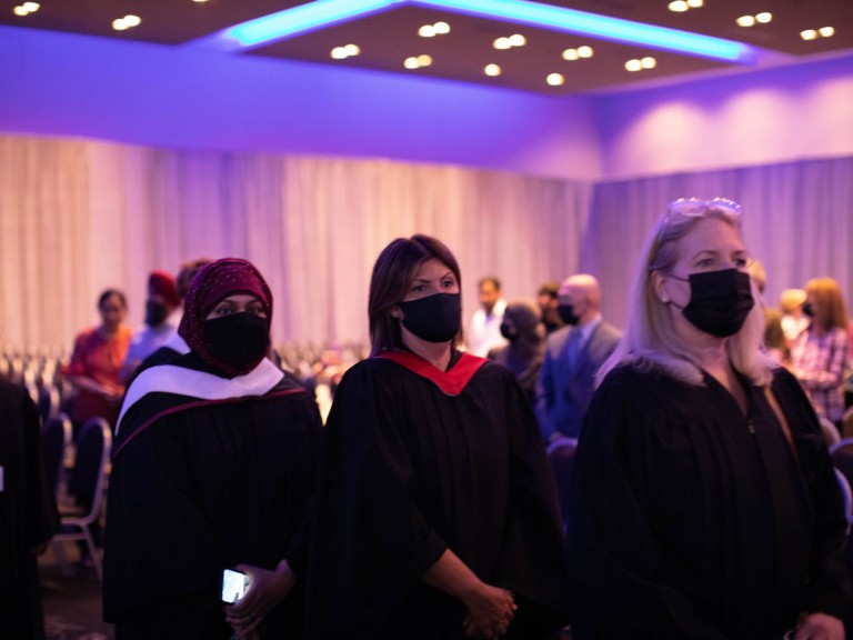 3 graduates waiting in line