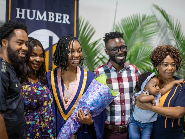 Graduate holding flowers with family