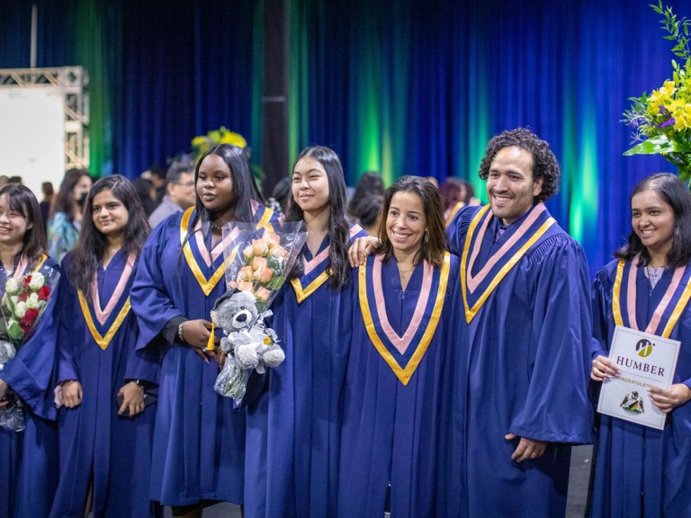 graduates pose for camera