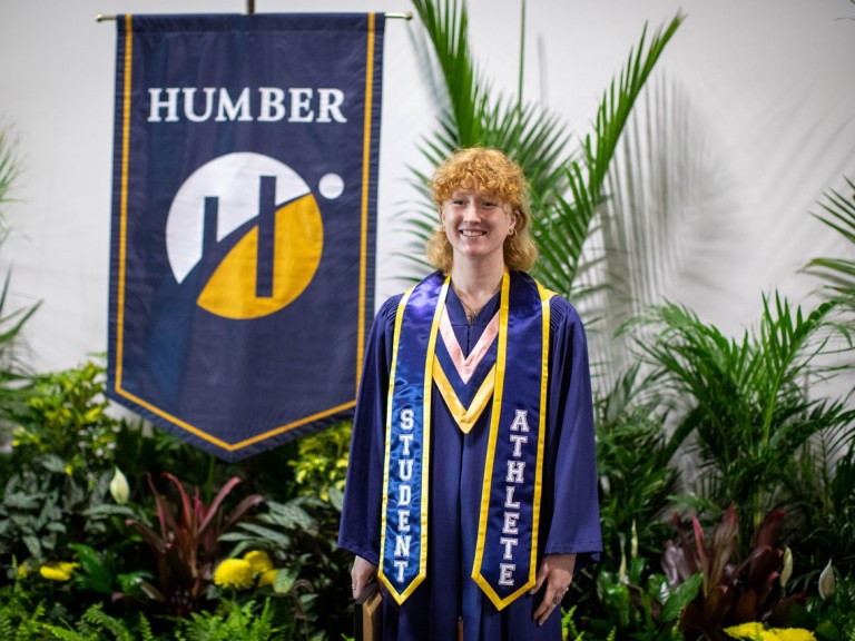 Graduate with banner around neck that reads student athlete