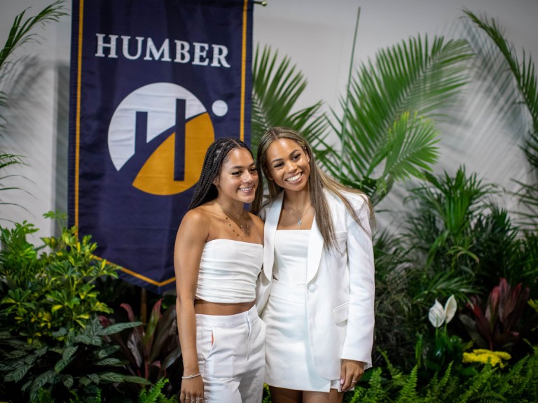 two people pose in front of Humber banner