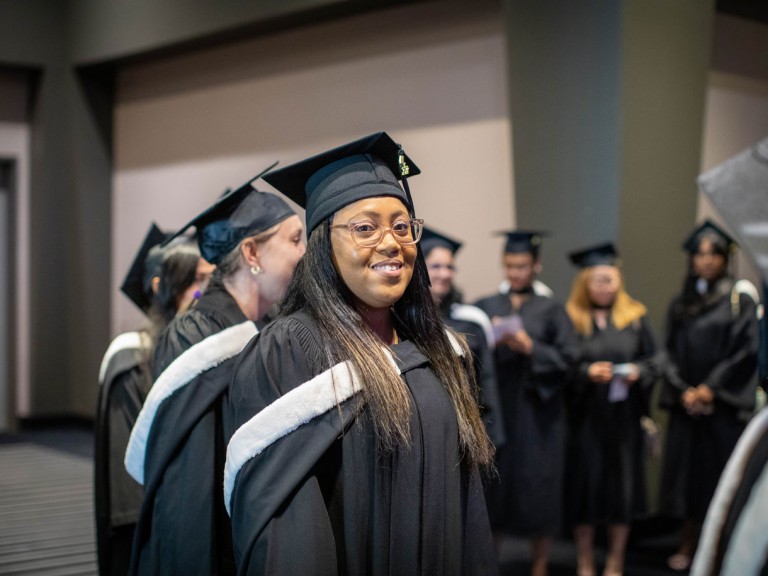 graduates in black caps standing in formation