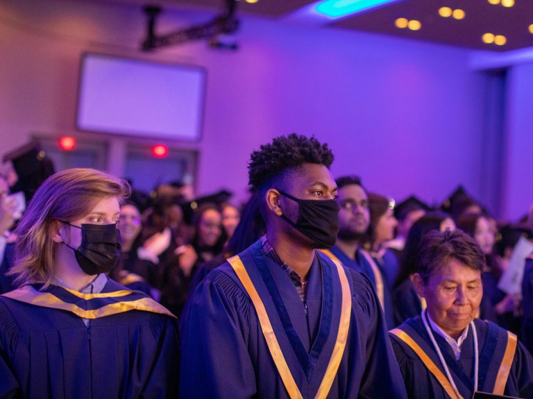Humber graduates standing at their seats with face masks on