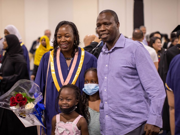 Humber graduate with roses poses with family
