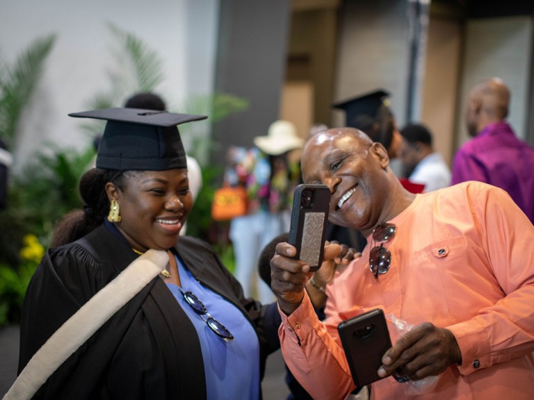 Person shows graduate their cell phone
