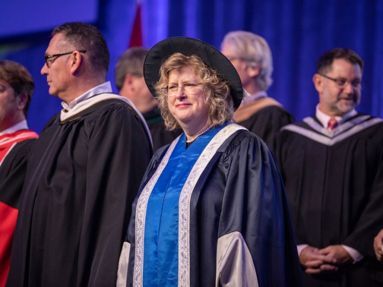 Faculty members in robes on stage