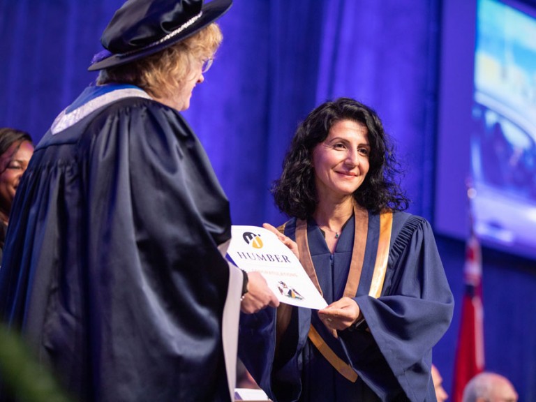 Graduate receiving certificate from Humber president