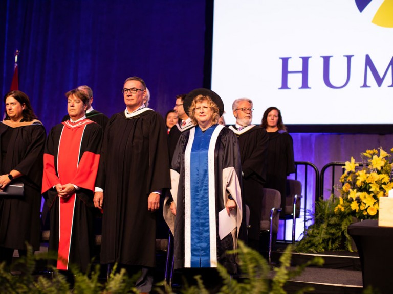 Faculty members standing on stage