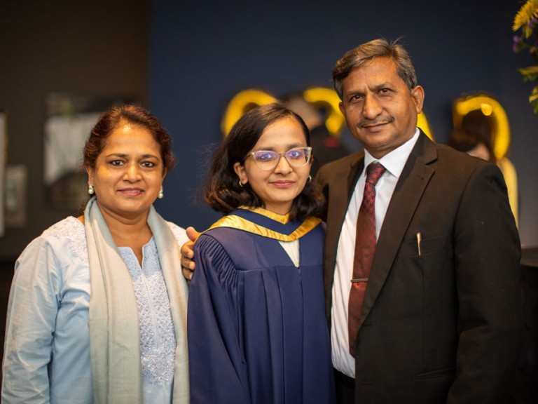 Grad posing with their parents