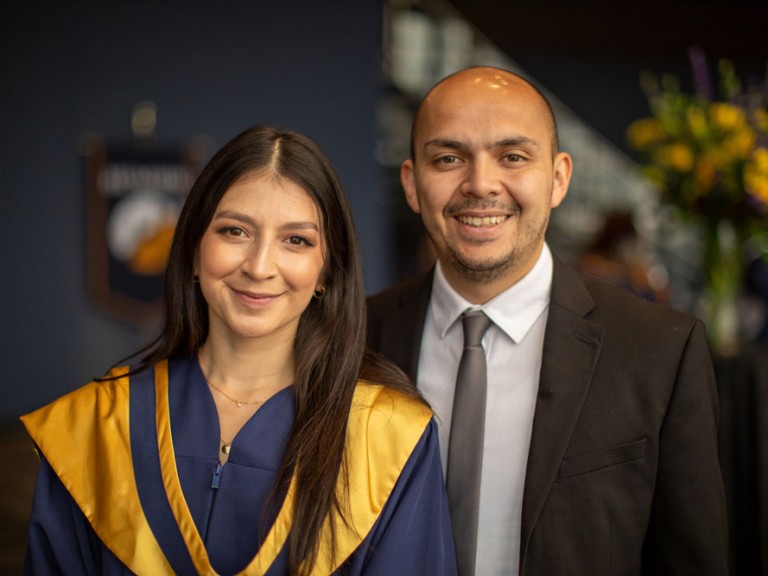 Grad smiling with another person for photo