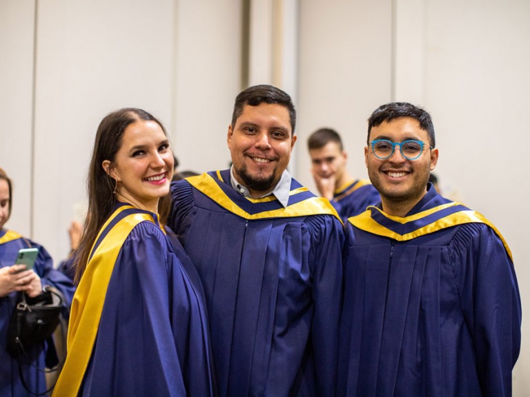 Three grads smiling for camera